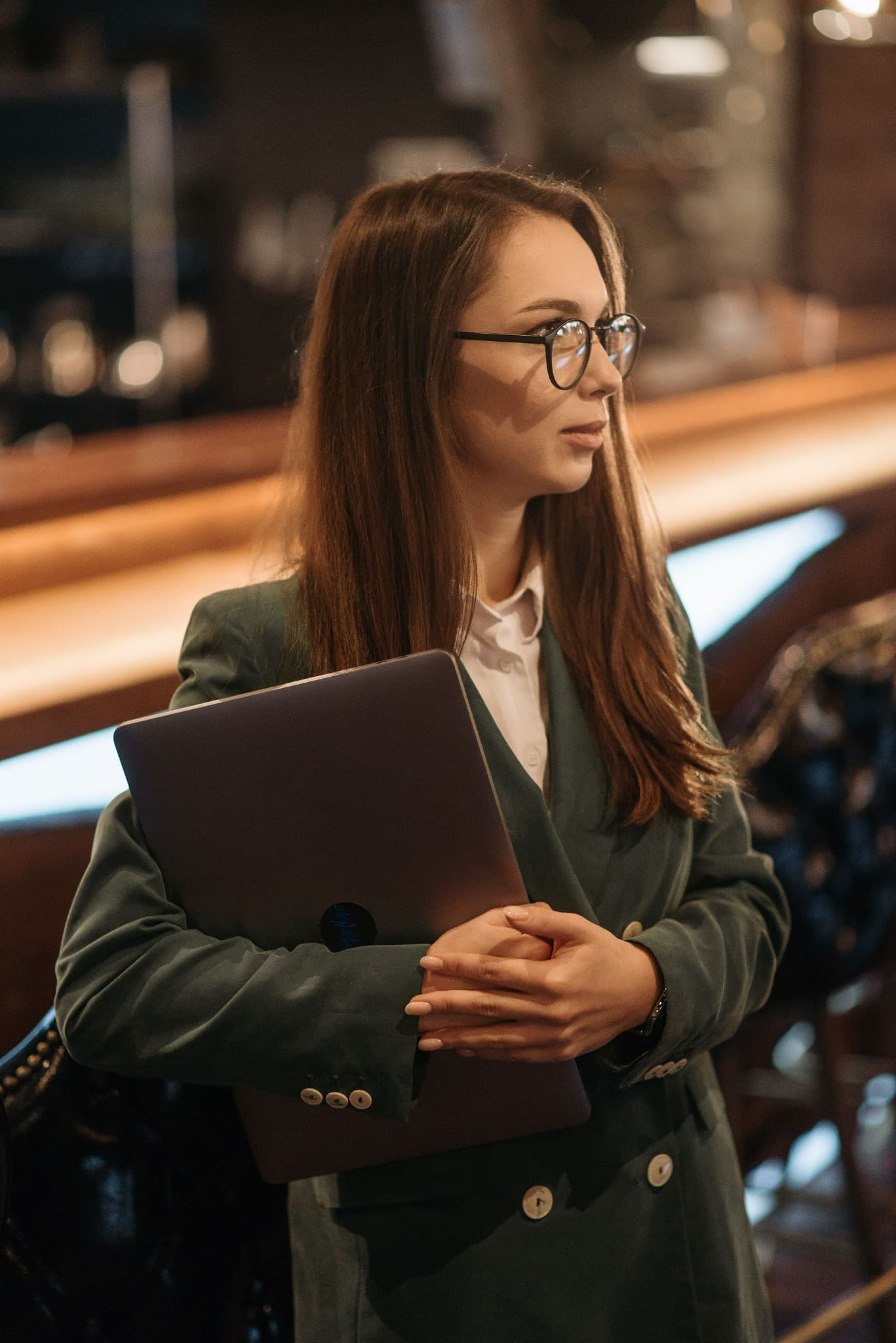 A professional carrying a laptop in a modern workplace