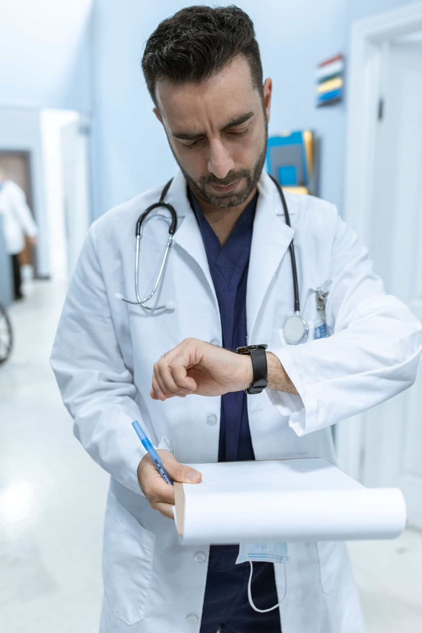 A physician reviewing a chart while working in a hospital