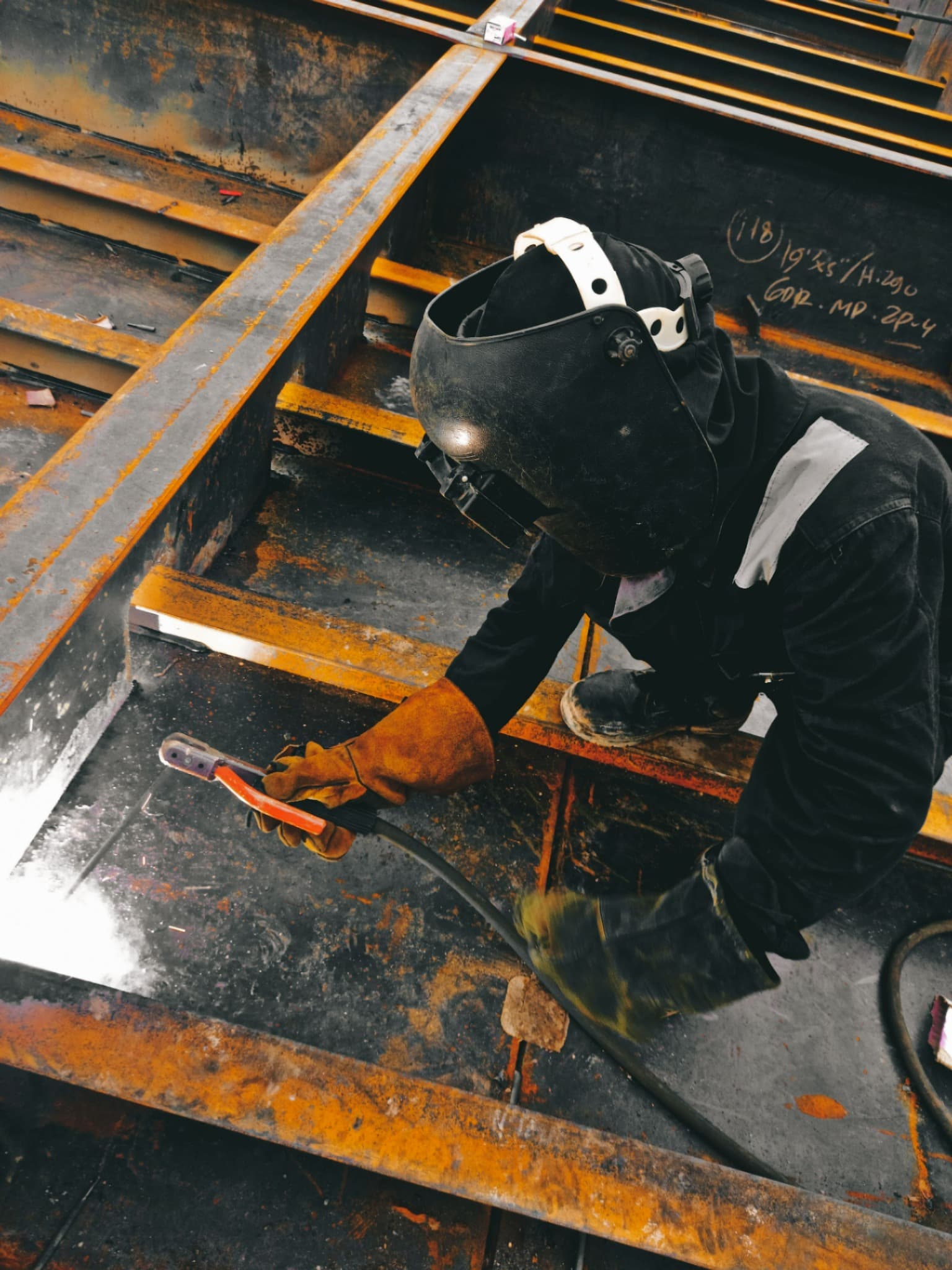 A welder working on a steel structure